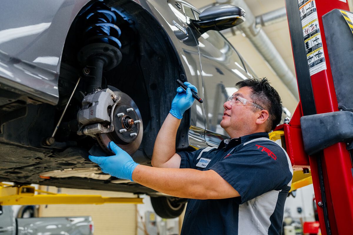 Toyota Service Technician inspecting vehicle brakes